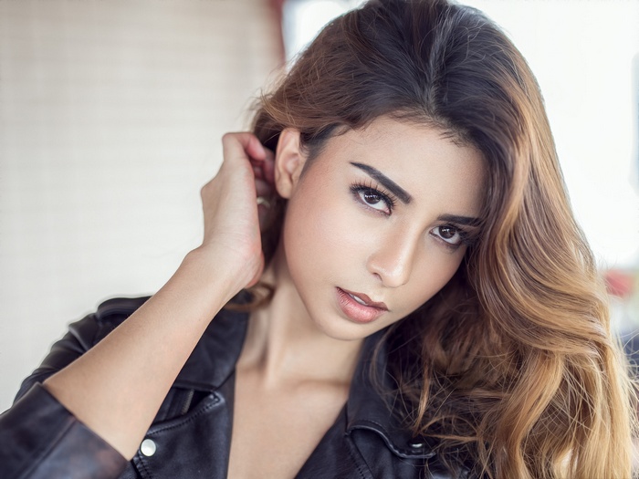 Woman with long brown hair wearing a leather jacket