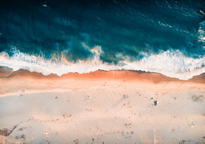 Aerial view of a sandy beach with ocean waves