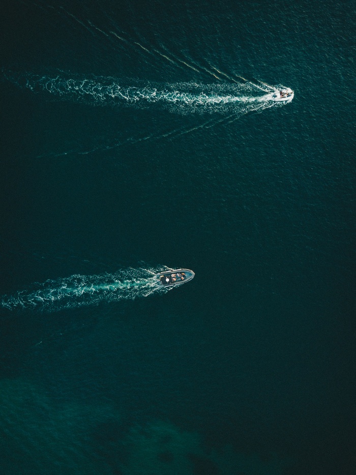 Two boats sailing on a dark blue ocean