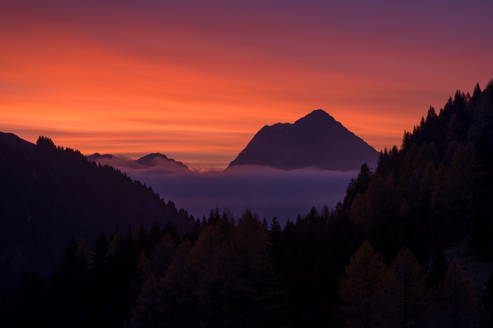 Mountains and trees at sunset with colorful sky