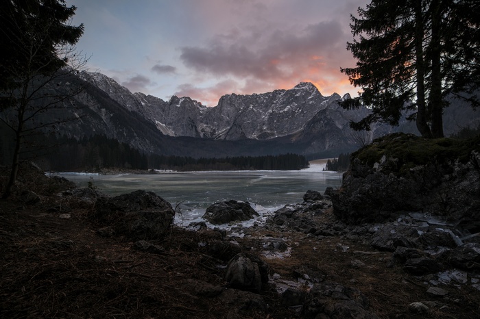 Frozen lake and mountains at sunset