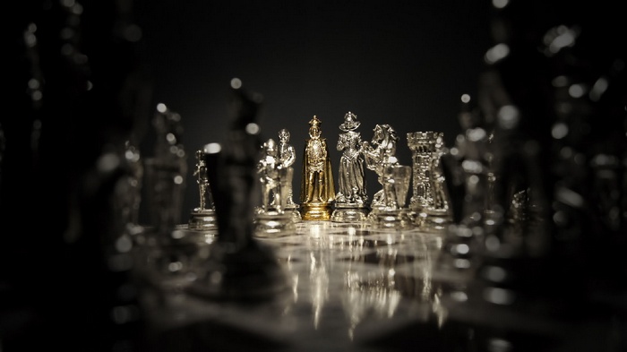 Gold King Chess Piece Among Silver Pieces