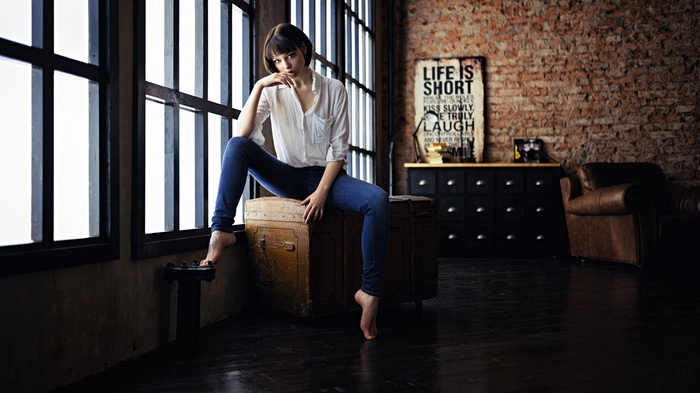 Olya Pushkina sitting barefoot by window