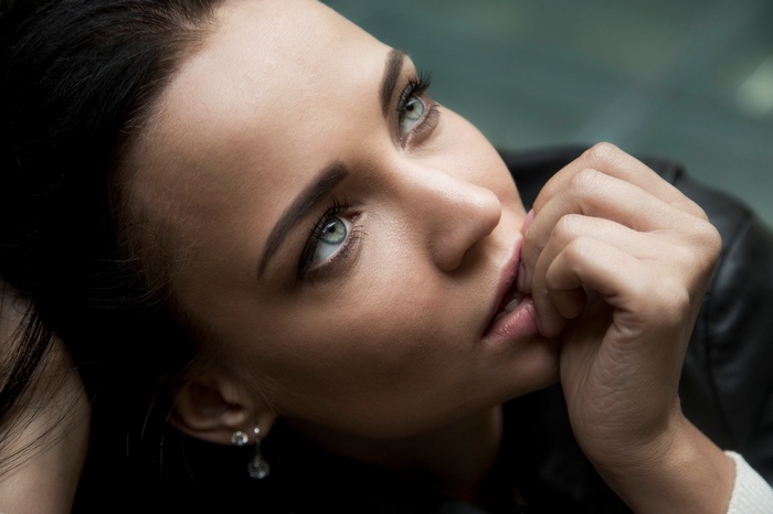 Close-up portrait of a woman with finger on lips