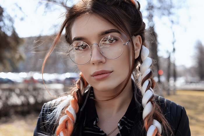 Woman with glasses and braided hair outdoors