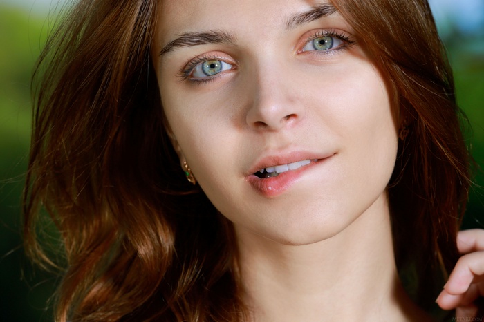 Olga Rich, redhead model with blue eyes biting lip
