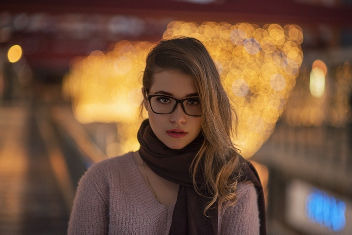 Woman with glasses and scarf in bokeh lights