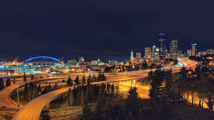 Seattle cityscape at night with stadium and highways