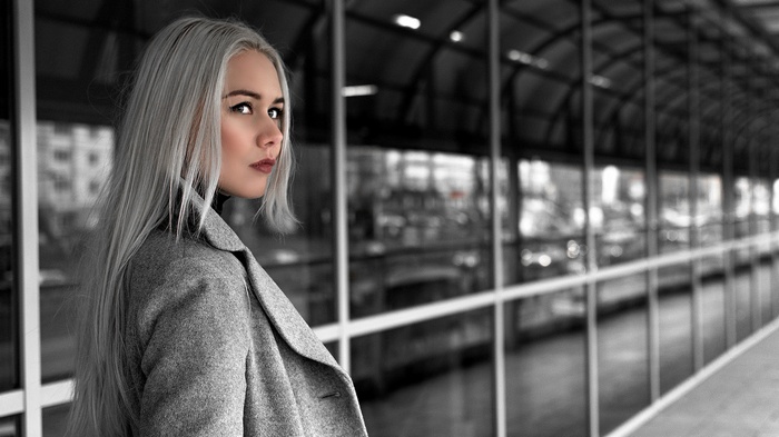 Woman with white hair in a grey coat