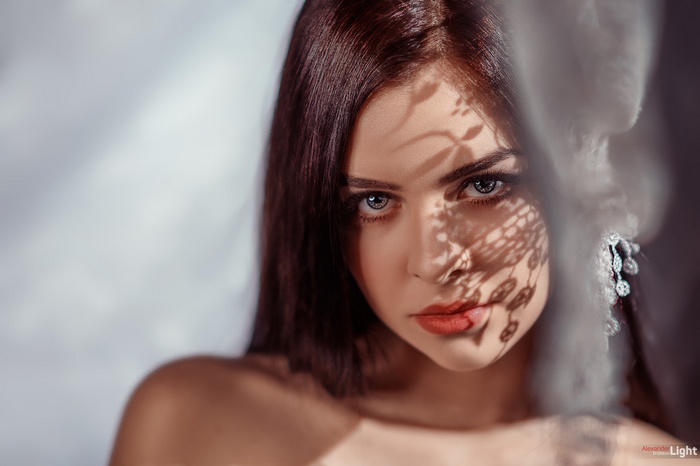Woman with lace shadow on face