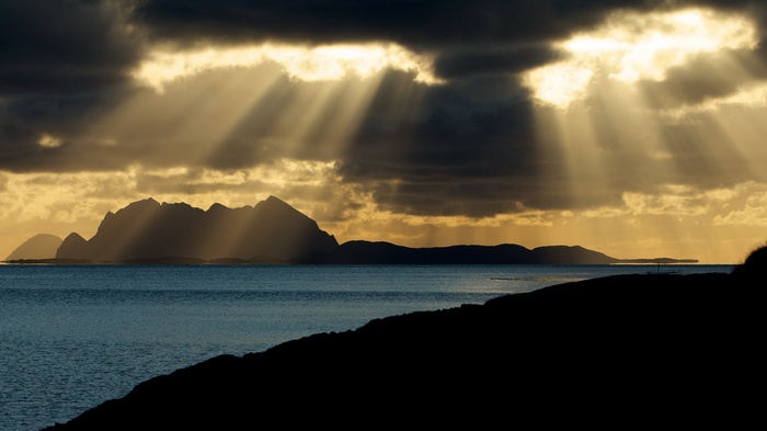 Sunbeams through clouds over islands and sea