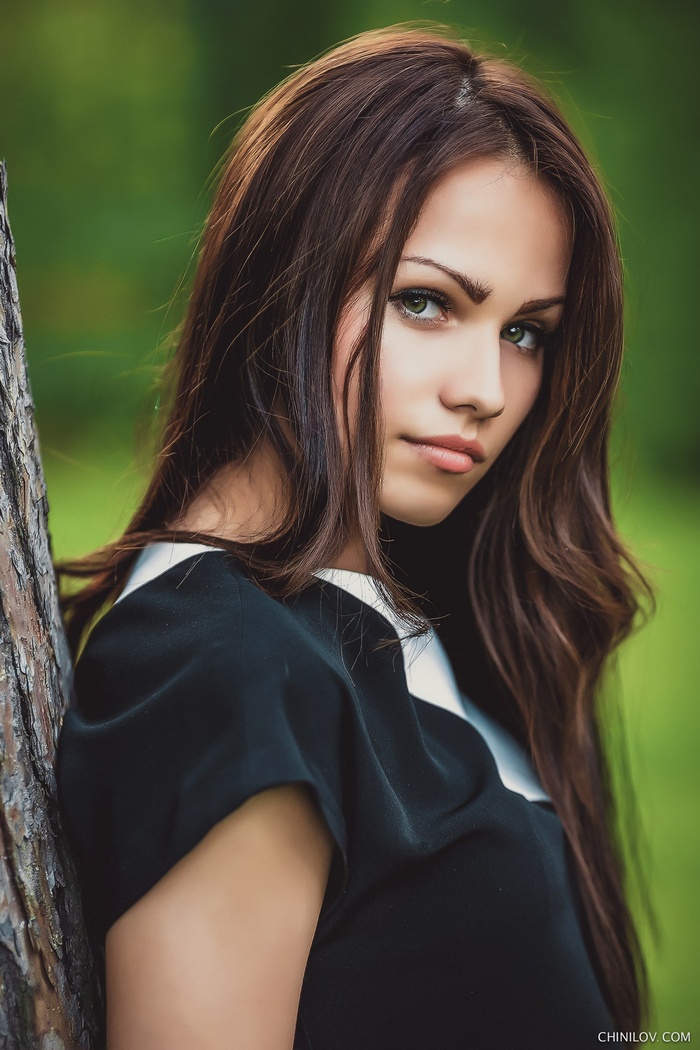 Portrait of a young woman with green eyes and long brown hair