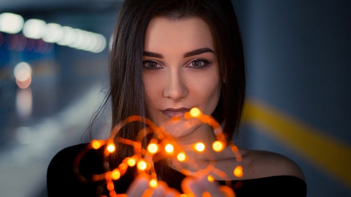 Woman holding glowing orange string lights