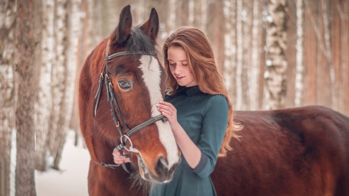 Girl with a horse in a winter forest