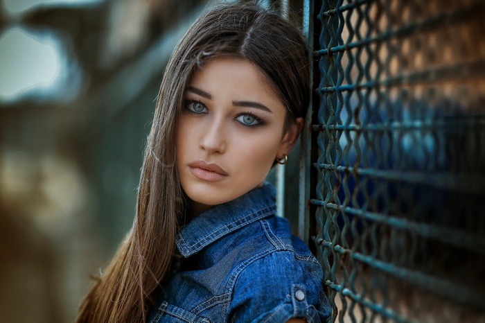 Woman leaning against a fence