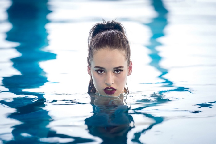Woman emerging from a swimming pool