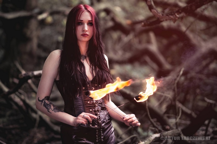 Woman with red streaks in black hair holding fire sticks