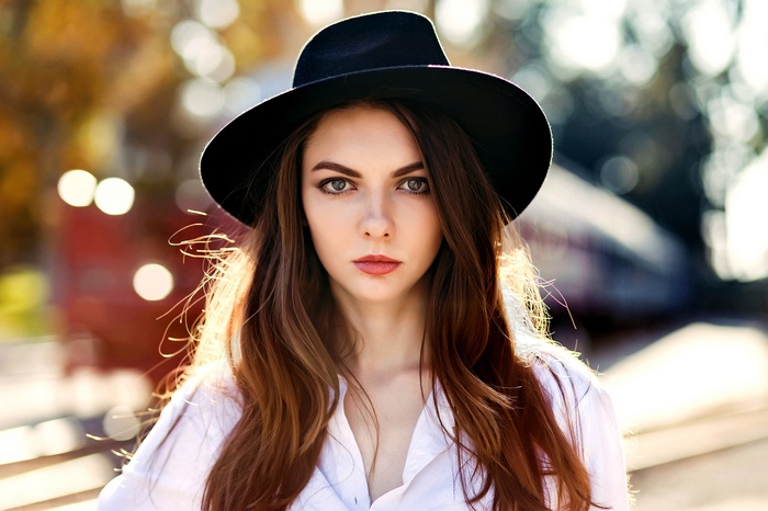 Woman wearing a black hat and white shirt outdoors