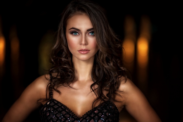 Woman with curly brown hair and blue eyes