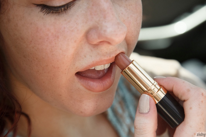 Woman applying lipstick