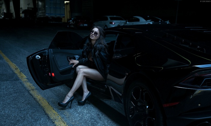 Woman in leather jacket and heels posing with Lamborghini Huracan