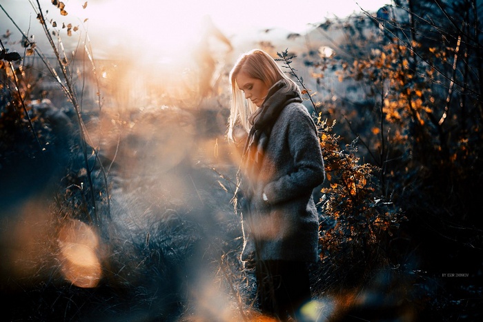 Woman in grey coat in nature during sunset