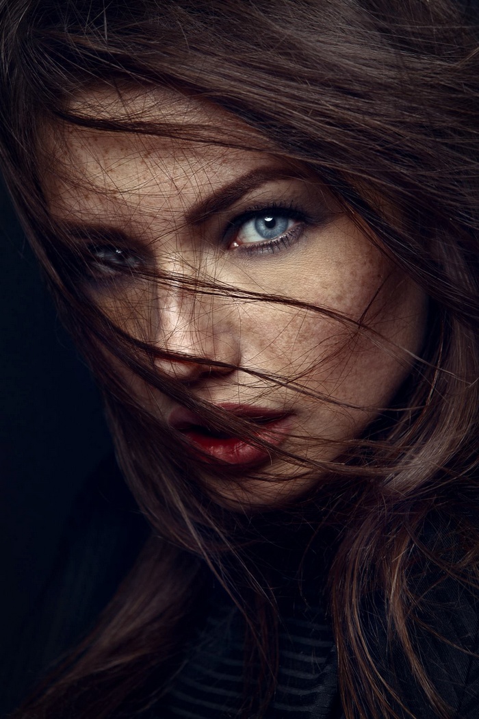 Woman with freckles and blue eyes, hair blowing