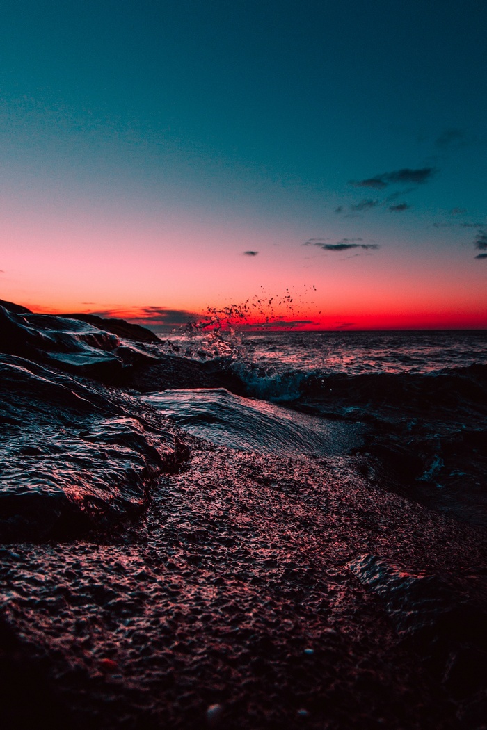 Ocean waves crashing on rocks at sunset