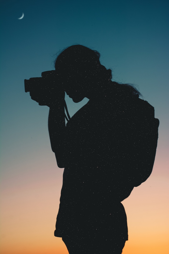 Silhouette of a photographer with stars and a crescent moon