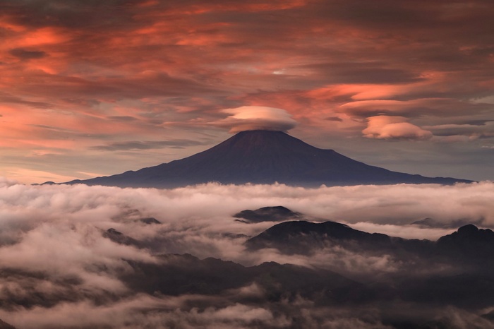 Volcano with lenticular cloud at sunset