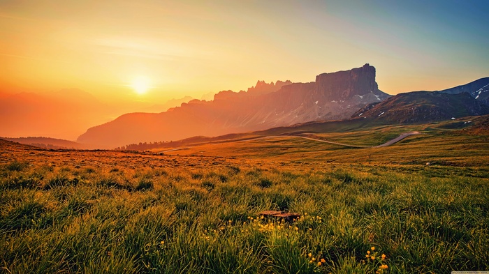 Sunset over a grassy mountain landscape