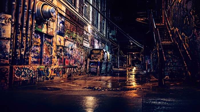 Graffiti-covered alleyway at night