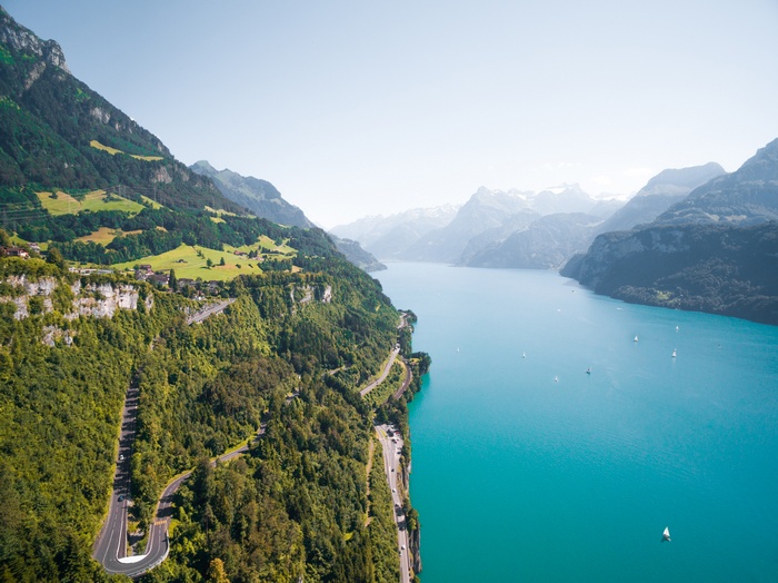 Winding road along a turquoise lake in the Swiss Alps