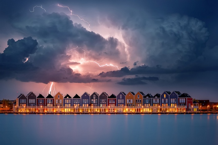 Row of colorful houses during a lightning storm
