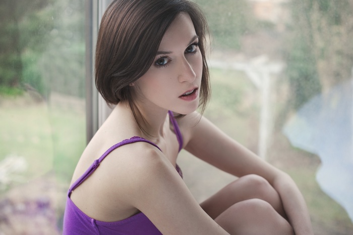 Woman with short brown hair wearing a purple top