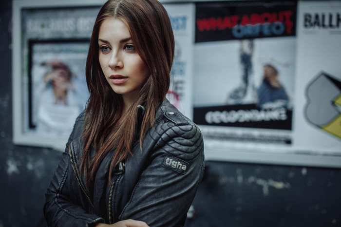 Woman with long brown hair wearing a leather jacket