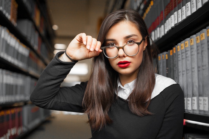 Woman with glasses and red lipstick in library
