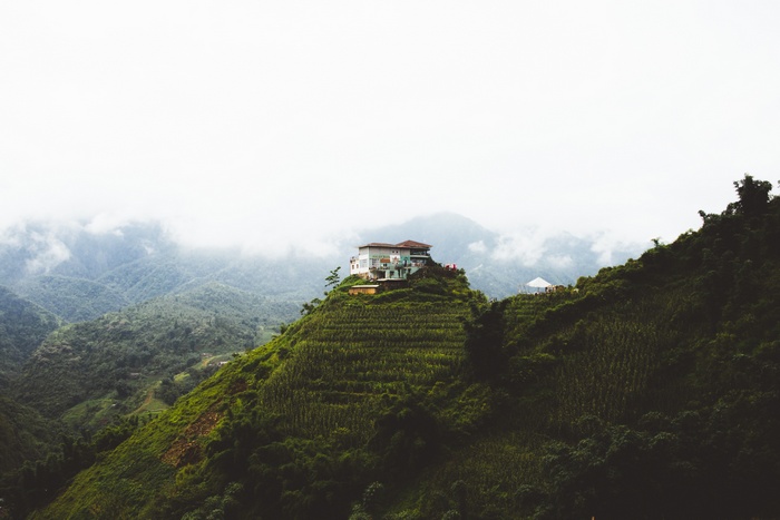 House on a terraced hillside with mountains