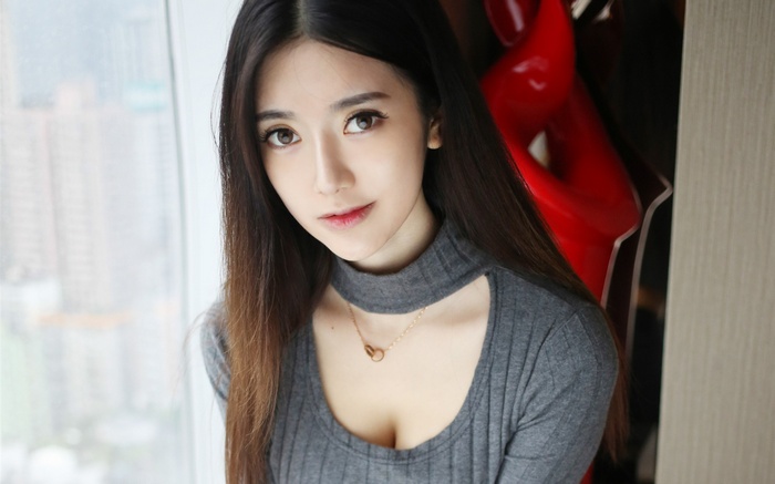 Asian woman wearing a grey sweater with a necklace
