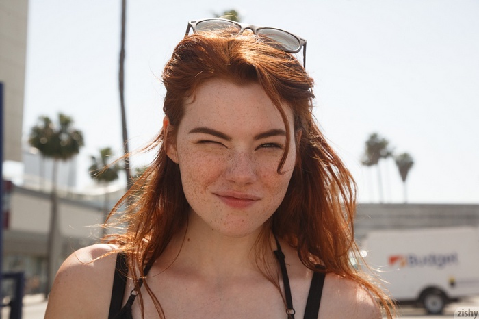 Sabrina Lynn winks outdoors with sunglasses