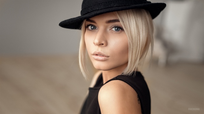 Woman with blonde hair wearing a black hat