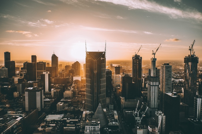 Melbourne cityscape at sunset with construction cranes