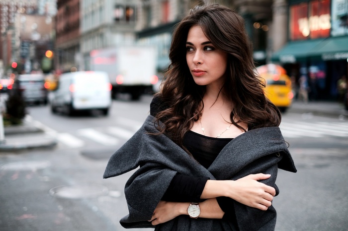 Woman in grey coat looking away in city