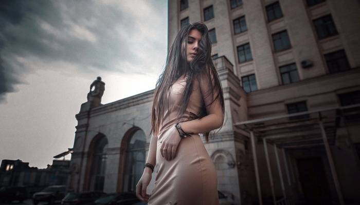 Woman in a dress standing in front of a building