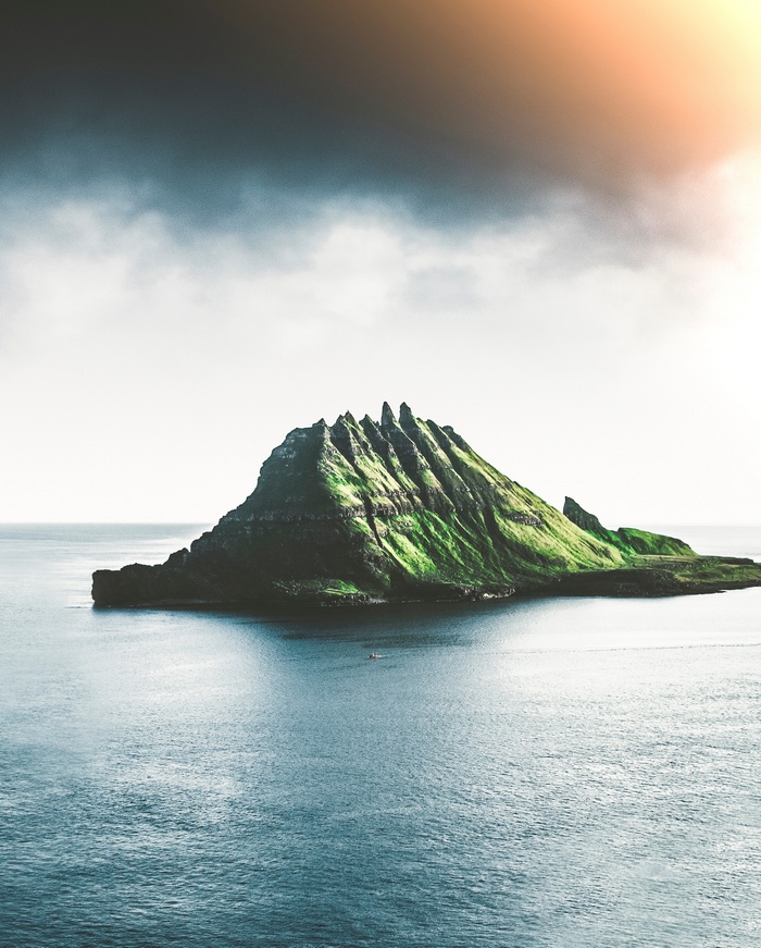 Island in the ocean with dramatic clouds