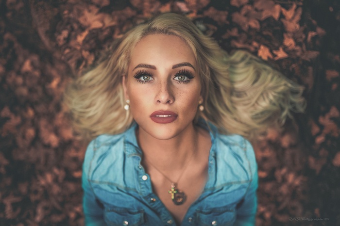 Woman with blonde hair and freckles wearing a denim shirt