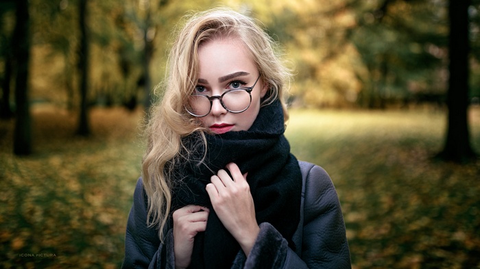 Woman with glasses and scarf in autumn park