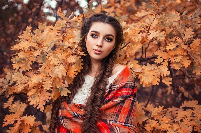 Woman with braids wrapped in a plaid blanket outdoors