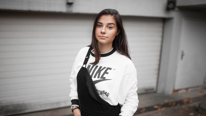Woman wearing Nike sweatshirt and overalls