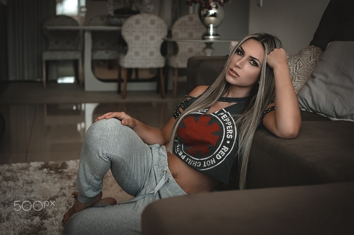 Woman in Red Hot Chili Peppers top sitting on floor